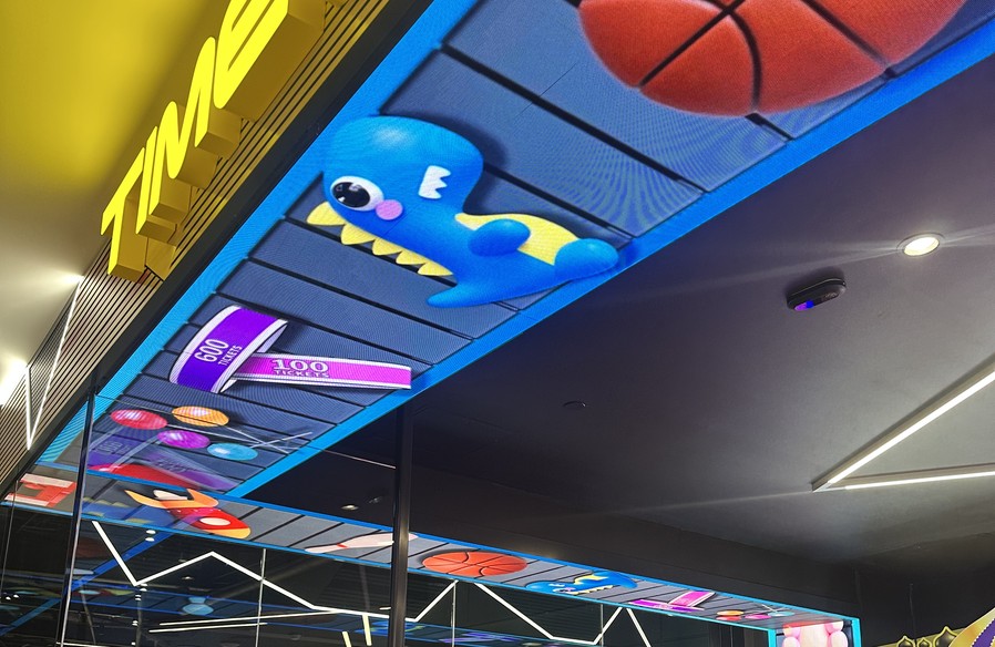 Curved LED soffit screen running arcade content over the Timezone shopfront